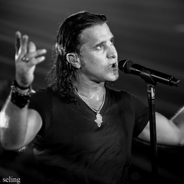 Scott Stapp with arms up singing