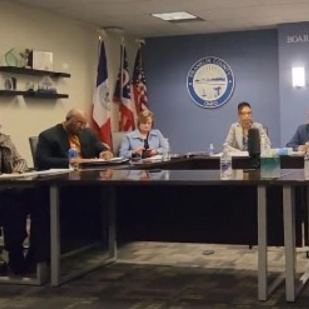 The hearing panel seated at a long table