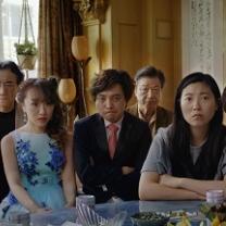 Very serious faced Asian people posing at a table all dressed up