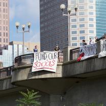 Fund Schools sign hung on overpass
