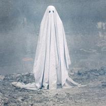 Person in a white sheet with two eye holes against an eerie gray background