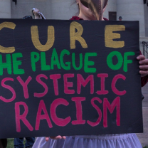 Sign saying Cure the Plague of Systemic Racism
