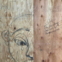 Face drawn crying on a piece of wood