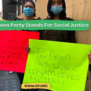 People holding signs and saying Green Party stands for social justice