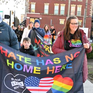 People marching with banner saying Hate has no home here