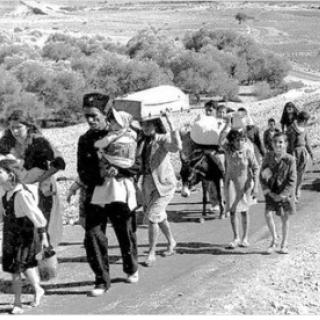 Families walking down a road with all their belongings