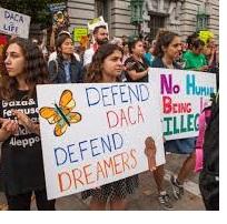 Young people with signs that say No Human Being is Illegal and Defend DACA, Defend Dreamers