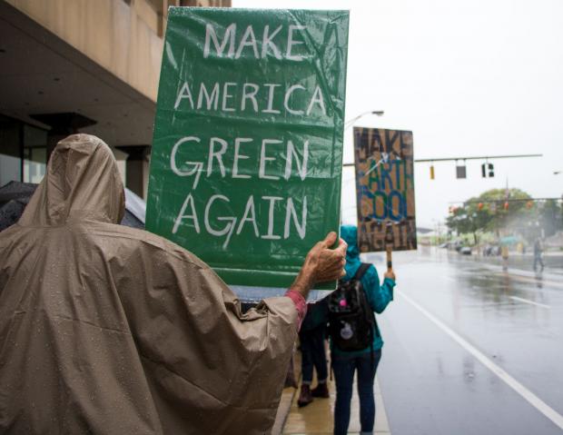Person holding sign saying making American Green again