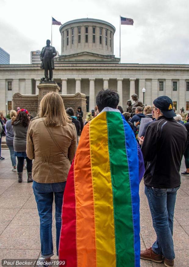 Protesters at the Ohio Statehouse one with a rainbow flag
