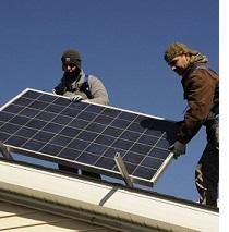 Two guys on a roof installing a solar panel