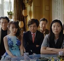 Very serious faced Asian people posing at a table all dressed up