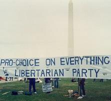 A long sign saying Pro choice on everything Libertarian Party held outside in front of the Washington monument