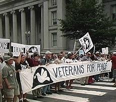 People holding a banner that says Veterans for Peace standing in front of a government building