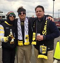 Three white guys wearing Save the Crew clothes smiling at the camera posing with their arms around each other
