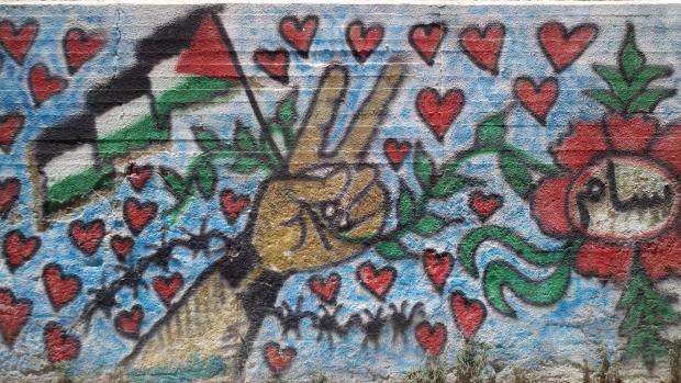 Peace sign and Palestinian flag surrounded by hearts