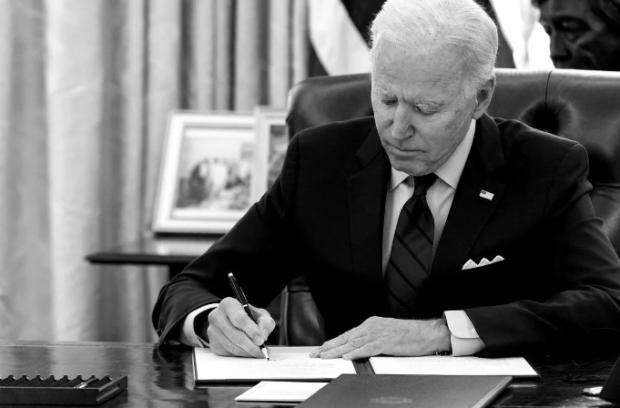 Biden at his desk signing something