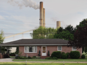 House with coal plant in background