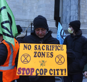 Protestor holding sign saying No Sacrifice Zones, Stop Cop City