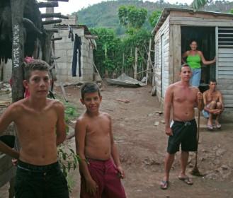 Cuban family standing outside small makeshift house