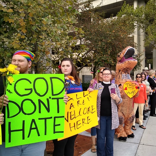 Line of counterprotestors holding signs one saying God Don't Hate