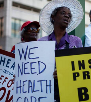 Woman holding sign saying We need Health Care