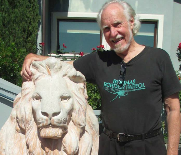 Jim Heddle standing next to a lion statue