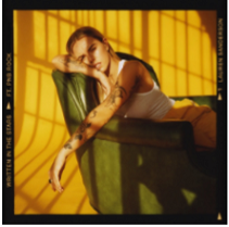 Young white woman lounging backwards in a chair against a yellow background