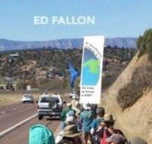 Landscape scene with line of people marching along a hill with cars going by