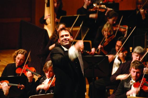 Man in front of orchestra conducting