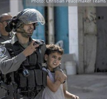 Heavily armed cop grabbing a very young child