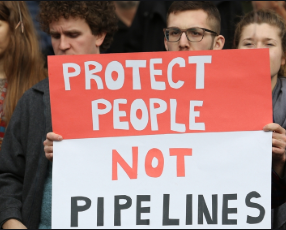 Demonstrators holding a sign that reads Protect People not Pipelines