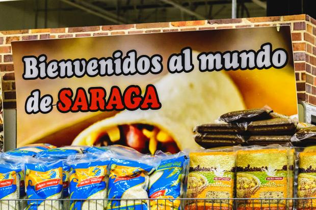 Sign in back of food at a grocery store saying Bienvenidos al de Saraga
