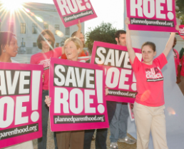 People holding Save Roe signs