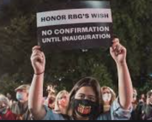 Man holding sign saying Honor RBG's wish