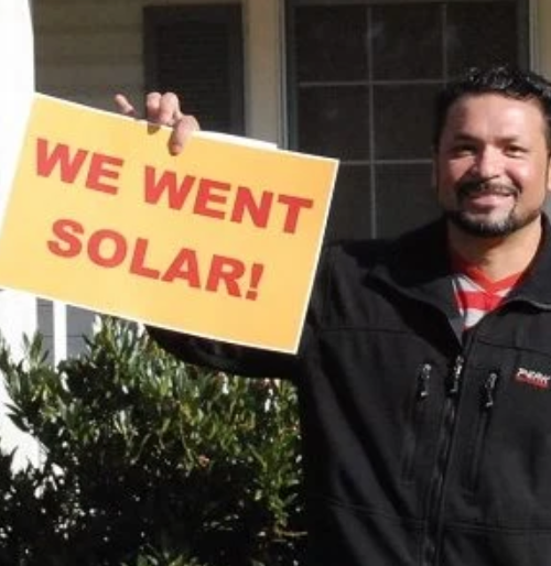 Guy holding sign saying We Went Solar