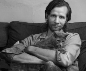 Man on couch holding a cat