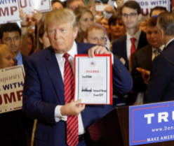 Trump holding up a sign