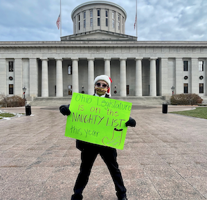 Man holding sign in front of Statehouse