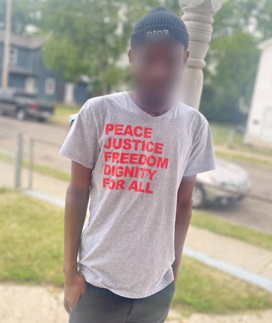 Man in T-shirt saying Peace, Justice, Freedom, Dignity for all