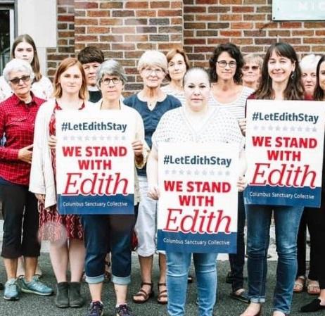 People holding signs saying We Stand with Edith
