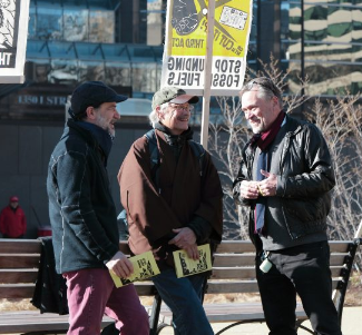 Three men talking outside at a protest