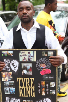 Man holding sign for Tyre