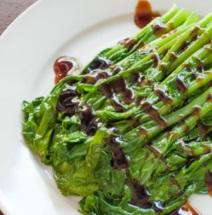Asparagus on a plate with a brown drizzle across it