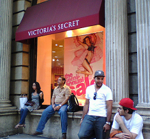 People sitting on a ledge outside a Victoria's Secret store