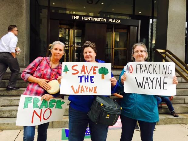Three women holding signs about saving the Wayne National Forest