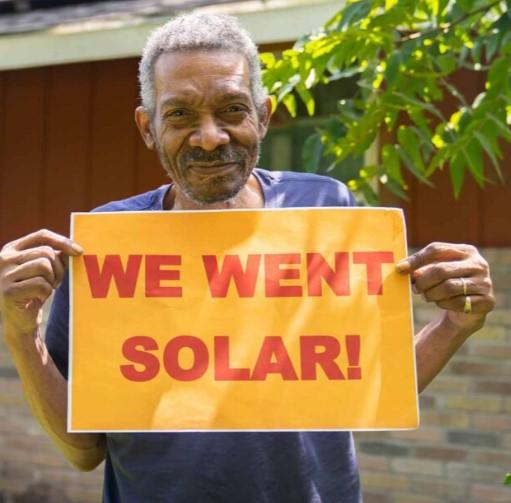 Man holding We Went Solar sign