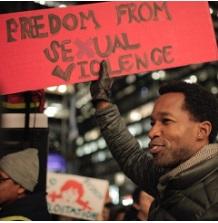 Black man holding a sign that says Freedom from Sexual Violence