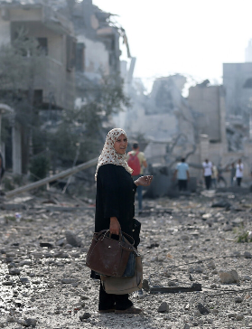 Woman in Gaza street with devastation all around