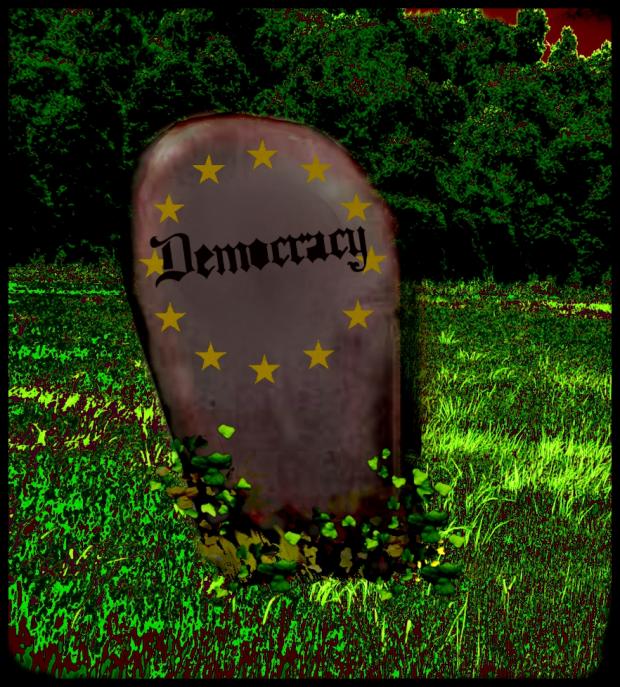 Tombstone that says Democracy on it in a grassy field