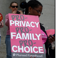 Black woman at rally holding a sign that says Pro privacy, pro family, pro choice